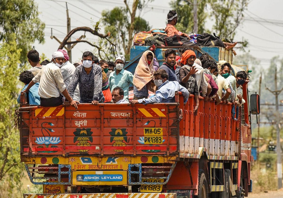 Migrants coming from Maharashtra board a truck to reach their native places in Uttar Pradesh and Jharkhand, amid the ongoing COVID-19 nationwide lockdown, in Bhopal, Tuesday, May 12, 2020. (PTI Photo)