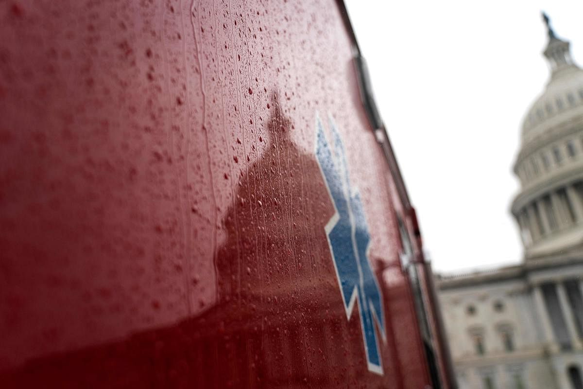 The US Capitol Building is reflected in on the side of an ambulance on March 25, 2020, in Washington, DC. Credit: AFP Photo