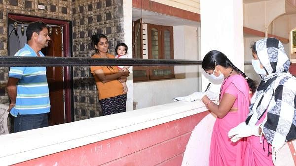 ASHA workers ask information on foreign travellers from residents of Vidyagiri in Dharawad on Sunday, as a precautionary measure to prevent the spread of COVID-19. Credit: DH Photo