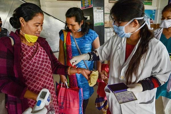 Medics put 'home quarantine' stamp on passengers after thermal screening in the wake of deadly coronavirus, at Guwahati Railway Station, Monday, March 23, 2020. (Credit: PTI Photo)