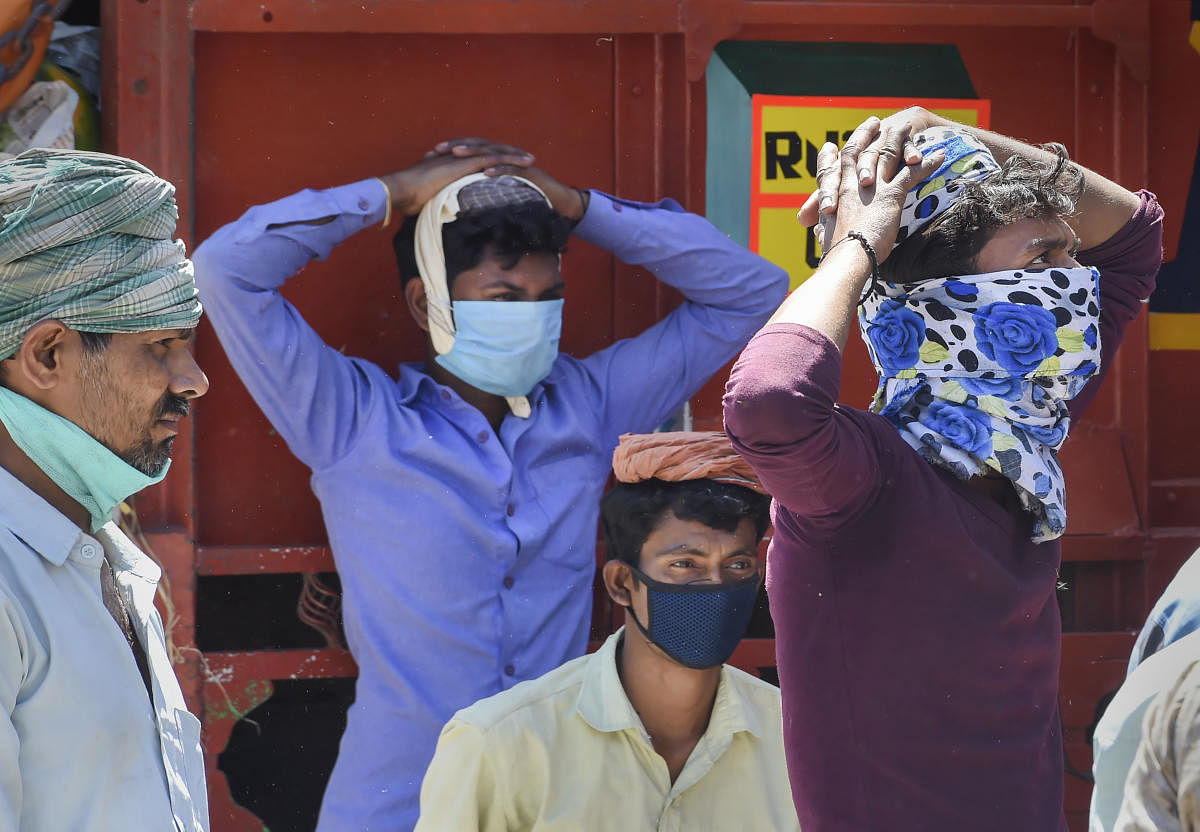  Labourers wait to get work at Azadpur Mandi during the nationwide lockdown, imposed in the wake of coronavirus pandemic, in New Delhi, Thursday, April 2, 2020. (PTI Photo)