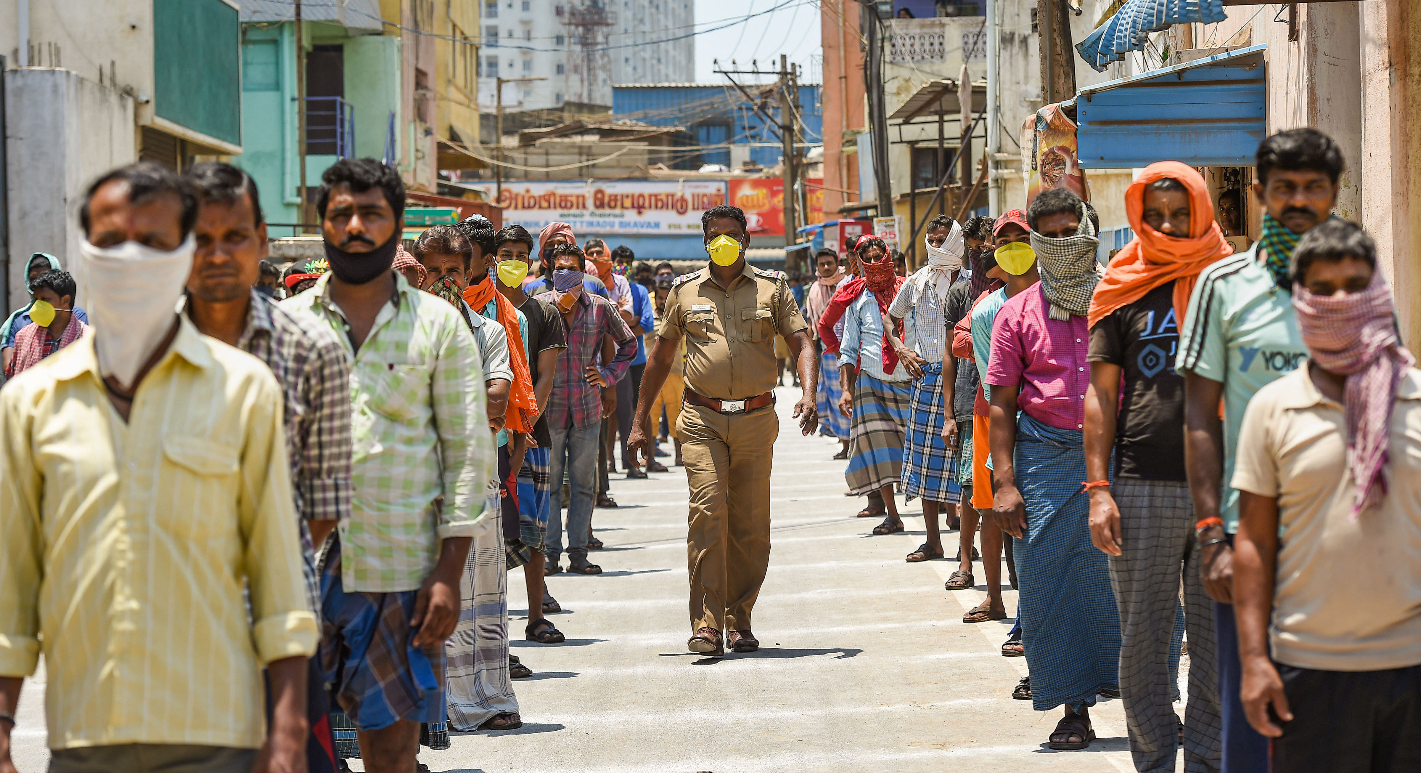 Stranded migrant workers wait for packaged food, distributed by Central Reserve Police Force (CRPF), during the nationwide lockdown in the wake of coronavirus. (PTI Photo)