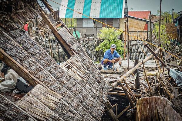 A resident tries to salvage belongings next to his house destroyed at the height of Typhoon Vongfong in San Policarpo town, Eastern Samar province on May 15, 2020, a day after the typhoon hit the town. (AFP Photo)