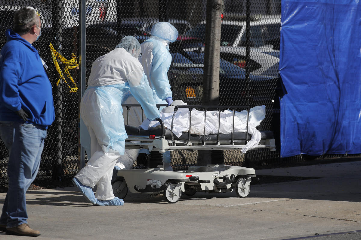 Healthcare workers wheel bodY of deceased person to morgue outside Wyckoff Heights Medical Center during outbreak of coronavirus disease (COVID-19) in New York. Credit: Reuters Photo