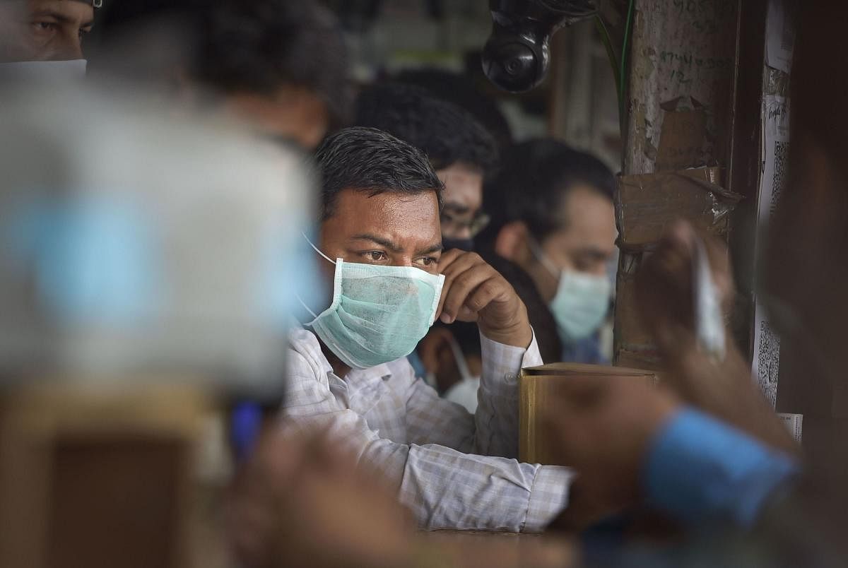 Salesmen at a chemist shop wear protective masks, in wake of the deadly novel coronavirus, outside Safdarjung Hospital, in New Delhi, Wednesday, March 4, 2020. (PTI Photo/Vijay Verma)