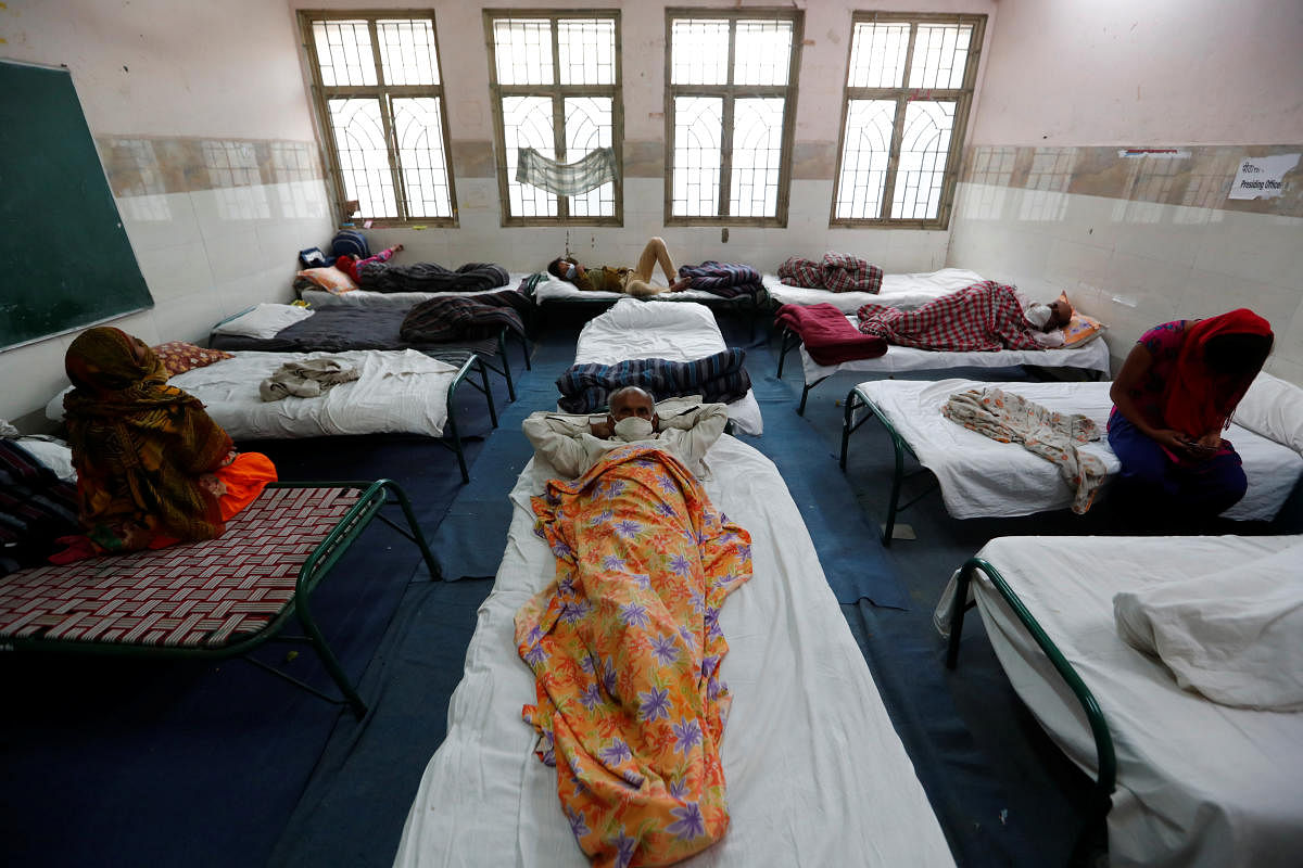 Migrant workers and their families rest in a room at a government-run temporary shelter at a school, during a 21-day nationwide lockdown to limit the spread of the coronavirus disease (Reuters Photo)