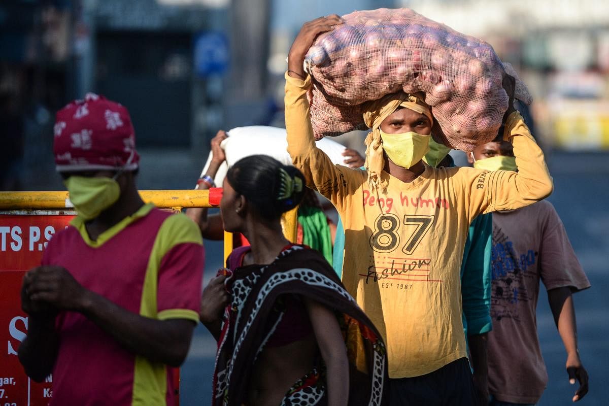 Migrant workers carrying sacks of groceries distributed at their workplace walk on a street during a nationwide lockdown against the coronavirus, in Chennai. AFP