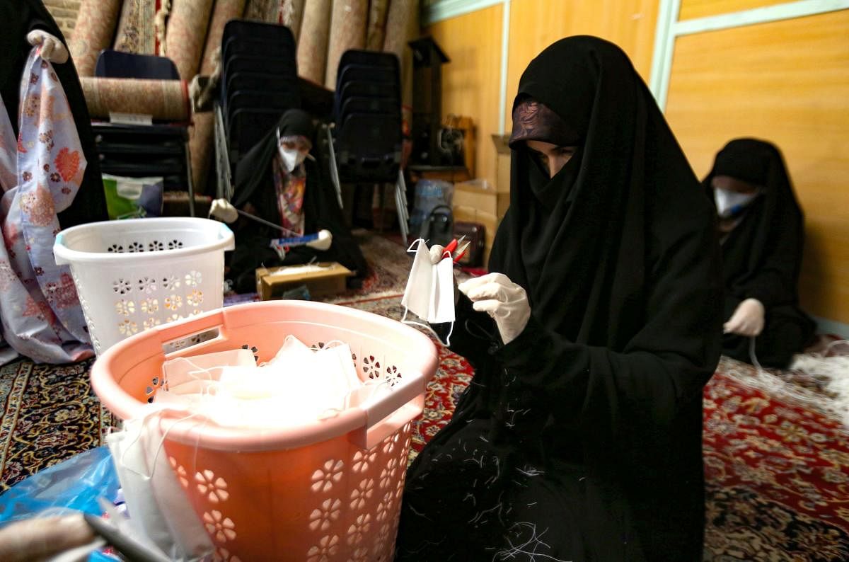 Iranian women, members of paramilitary organisation Basij, make face masks and other protective items at a mosque in the capital Tehran, amid the novel coronavirus pandemic crisis on April 5, 2020. Credit: AFP Photo