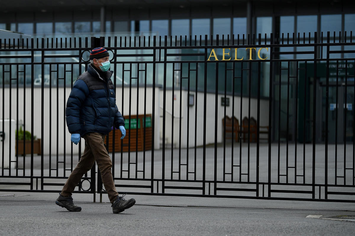 A man wearing a mask walks past the gate of the All England Lawn Tennis & Croquet Club as the spread of the coronavirus disease (COVID-19) continues, London, Britain, March 31, 2020. Credit: Reuters Photo