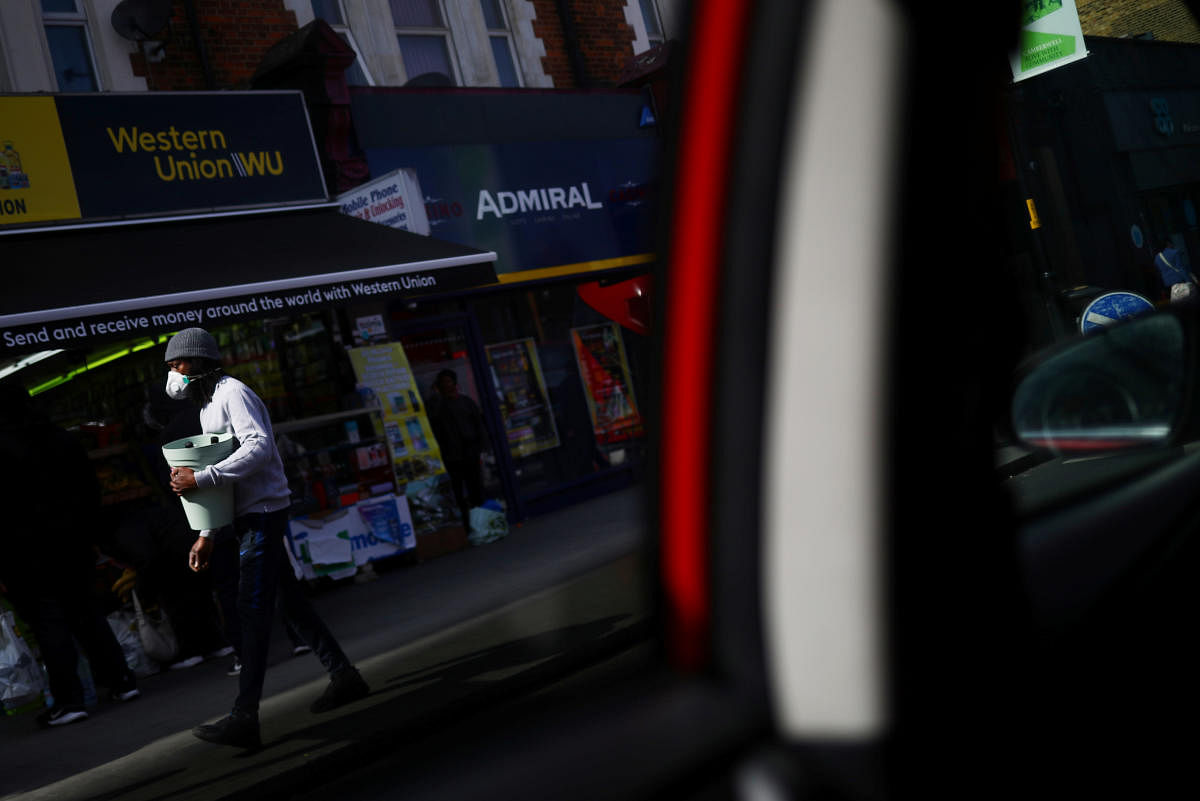 A man is seen wearing a protective face mask from a taxi window in Camberwell, as the spread of COVID-19 continues, London. Reuters
