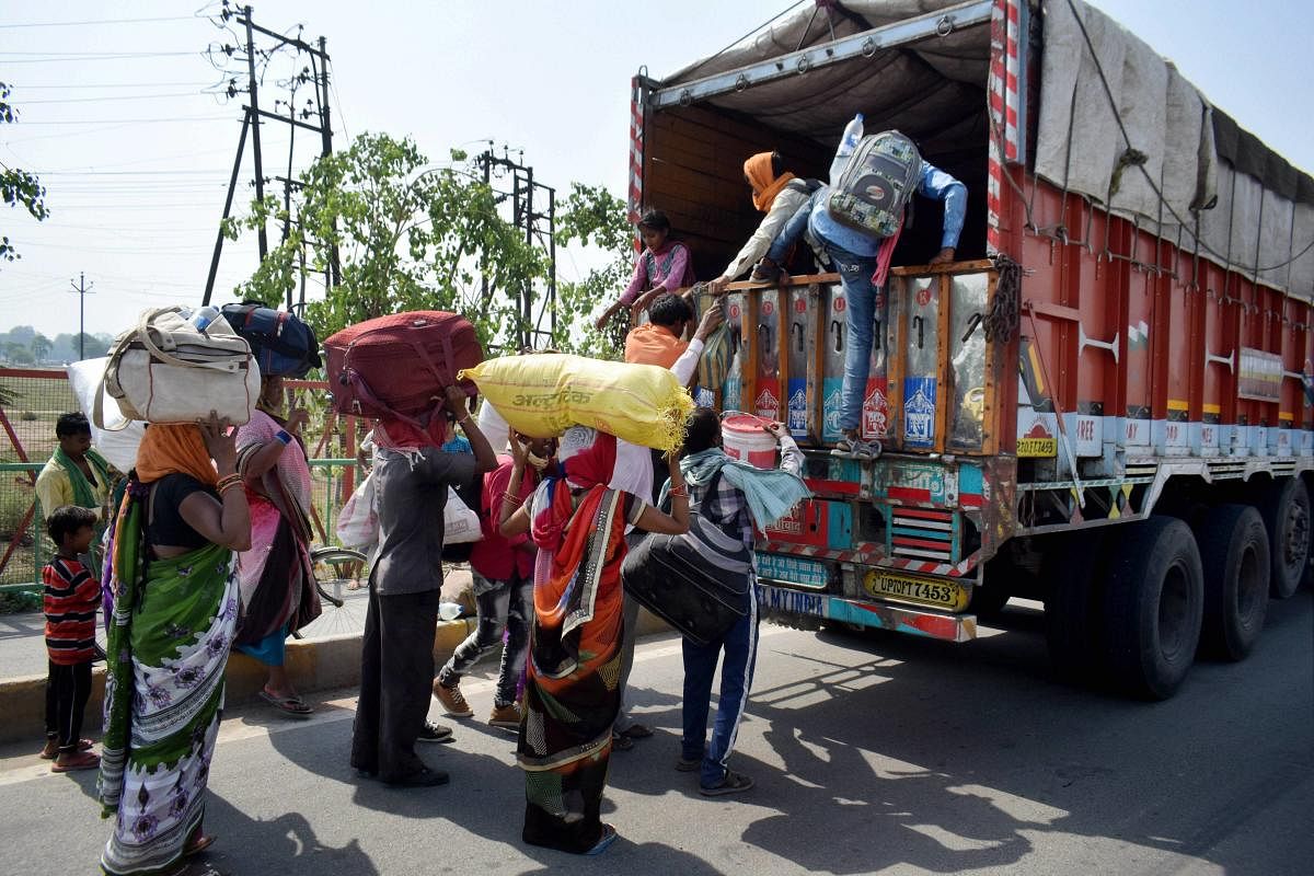 Migrants board a truck to reach their native places, during ongoing COVID-19 lockdown in Prayagraj (PTI Photo)