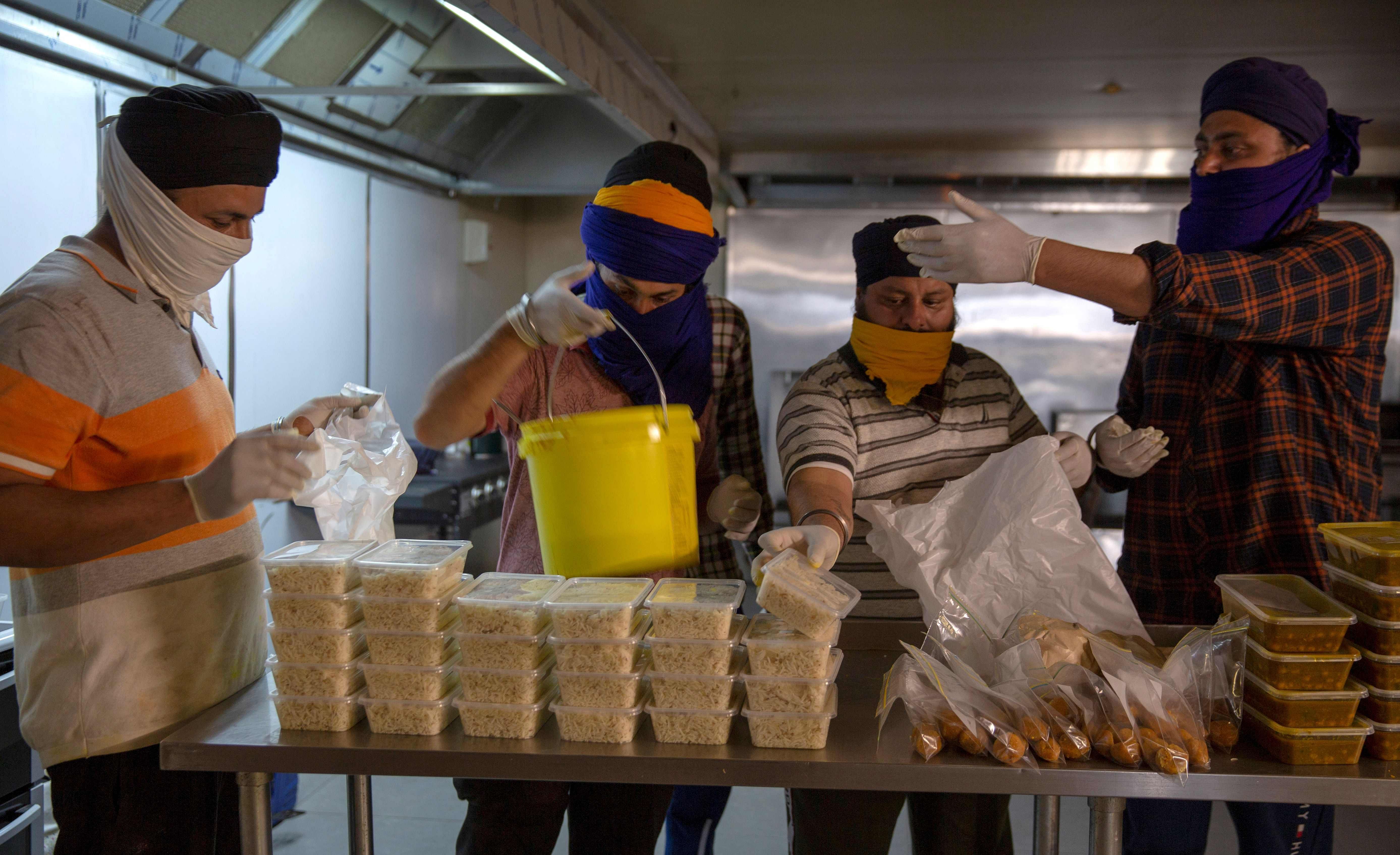 A photo taken in Melbourne shows volunteers preparing food deliveries as Sikh temples across Melbourne have become one of the centres of support for both medical workers and those self isolating. (AFP)