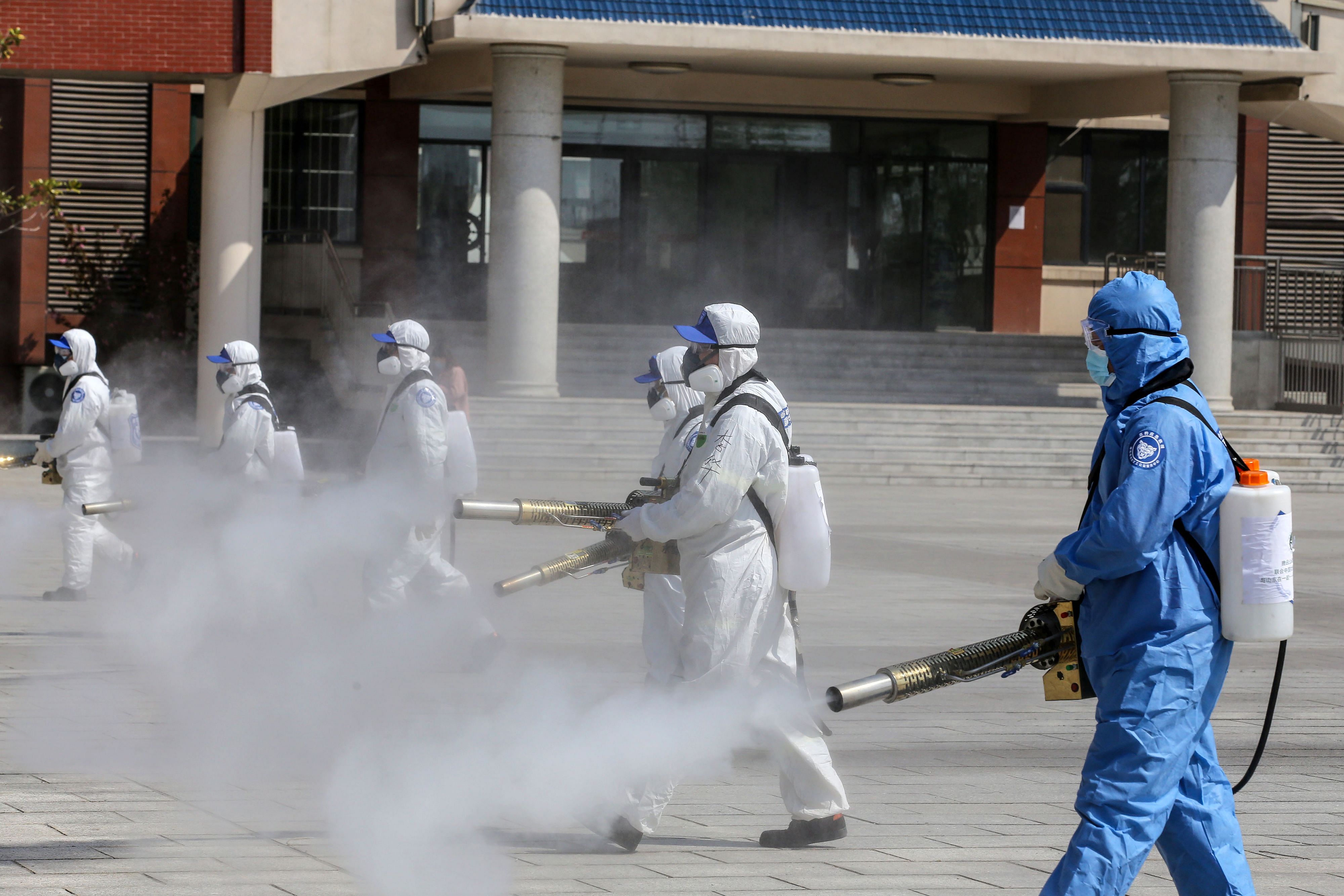 Volunteers spraying disinfectant in the compounds of a school as it prepares to reopen after the term opening was delayed due to the COVID-19 coronavirus outbreak, in Weifang in China's eastern Shandong province. (AFP Photo)