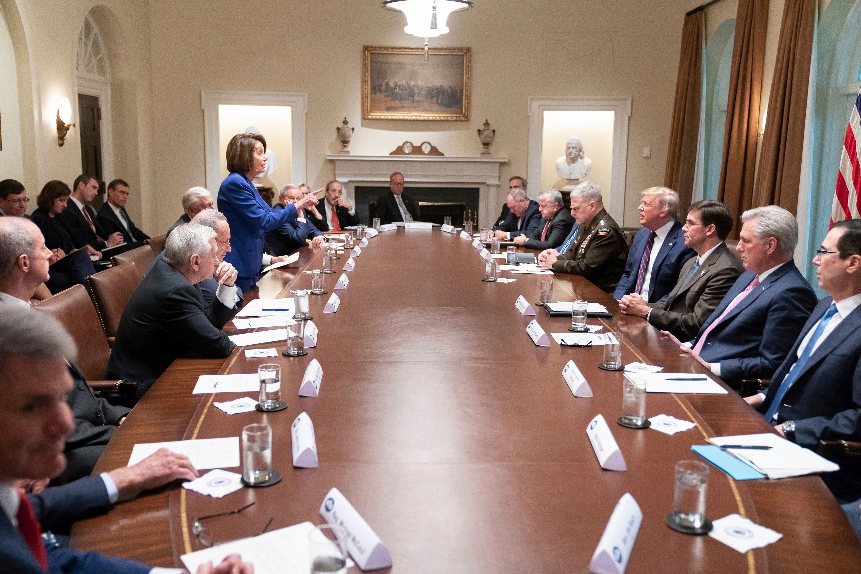 White House, President Donald Trump, center right, meets with House Speaker Nancy Pelosi, standing left, Congressional leadership and others, Wednesday, Oct. 16, 2019, in the Cabinet Room of the White House in Washington. (AP Photo)