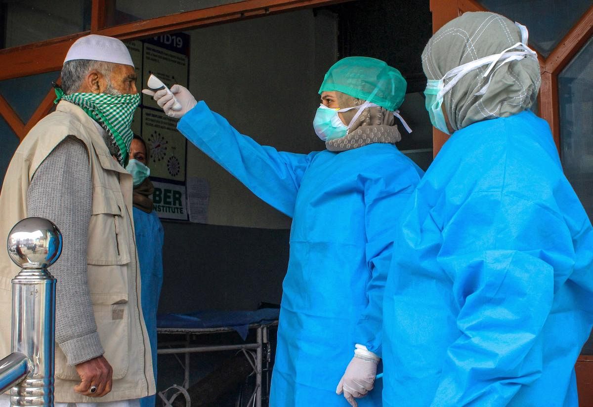 Doctors wearing protective gear scan visitors at the entrance of a hospital in wake of coronavirus outbreak, during the nationwide lockdown, in Srinagar, Thursday, April 2, 2020. (PTI Photo)