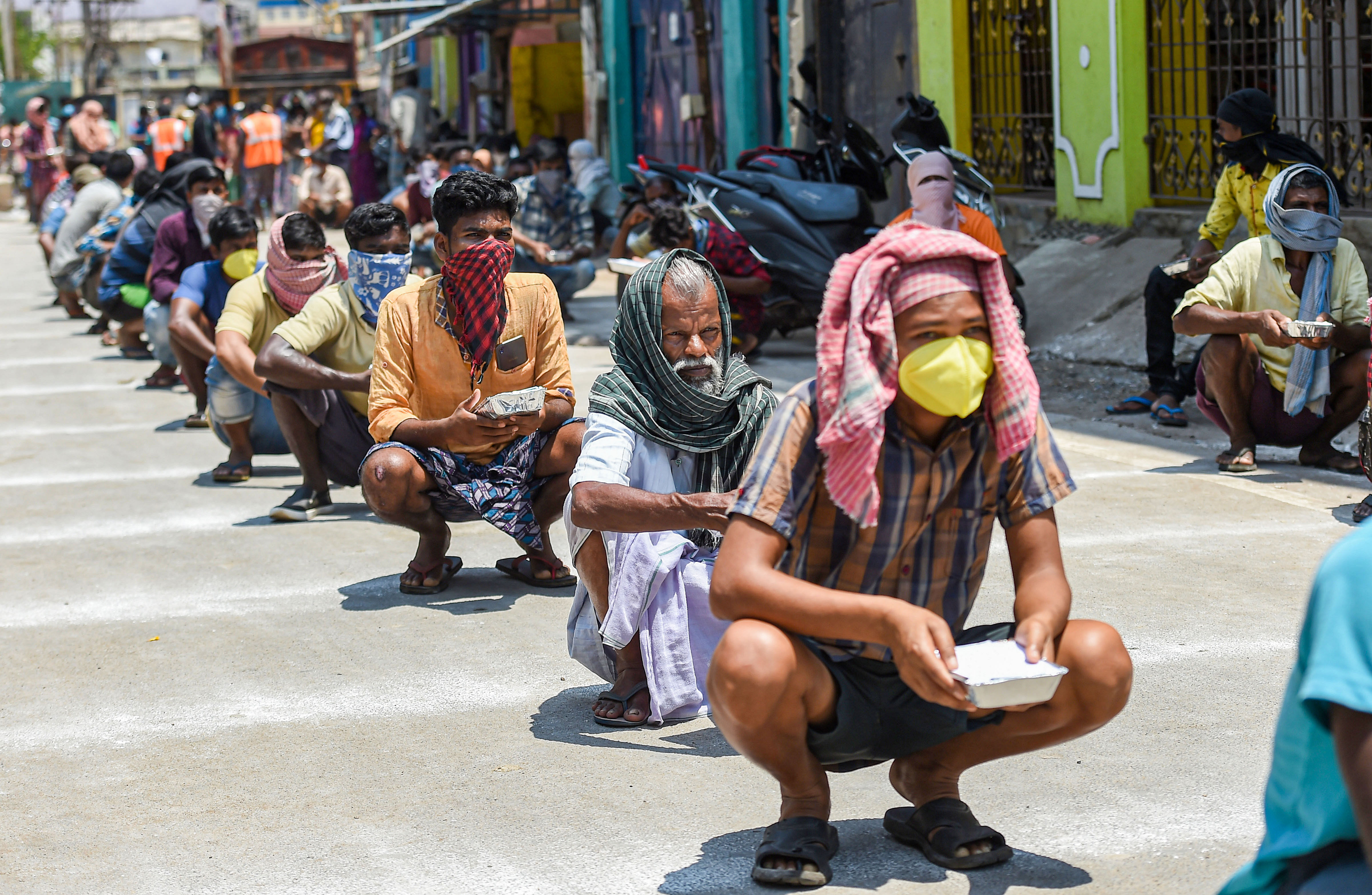 Stranded migrant workers maintain social distance as they wait for packaged food, distributed by Central Reserve Police Force (CRPF), during the nationwide lockdown in the wake of coronavirus pandemic. (PTI Photo)