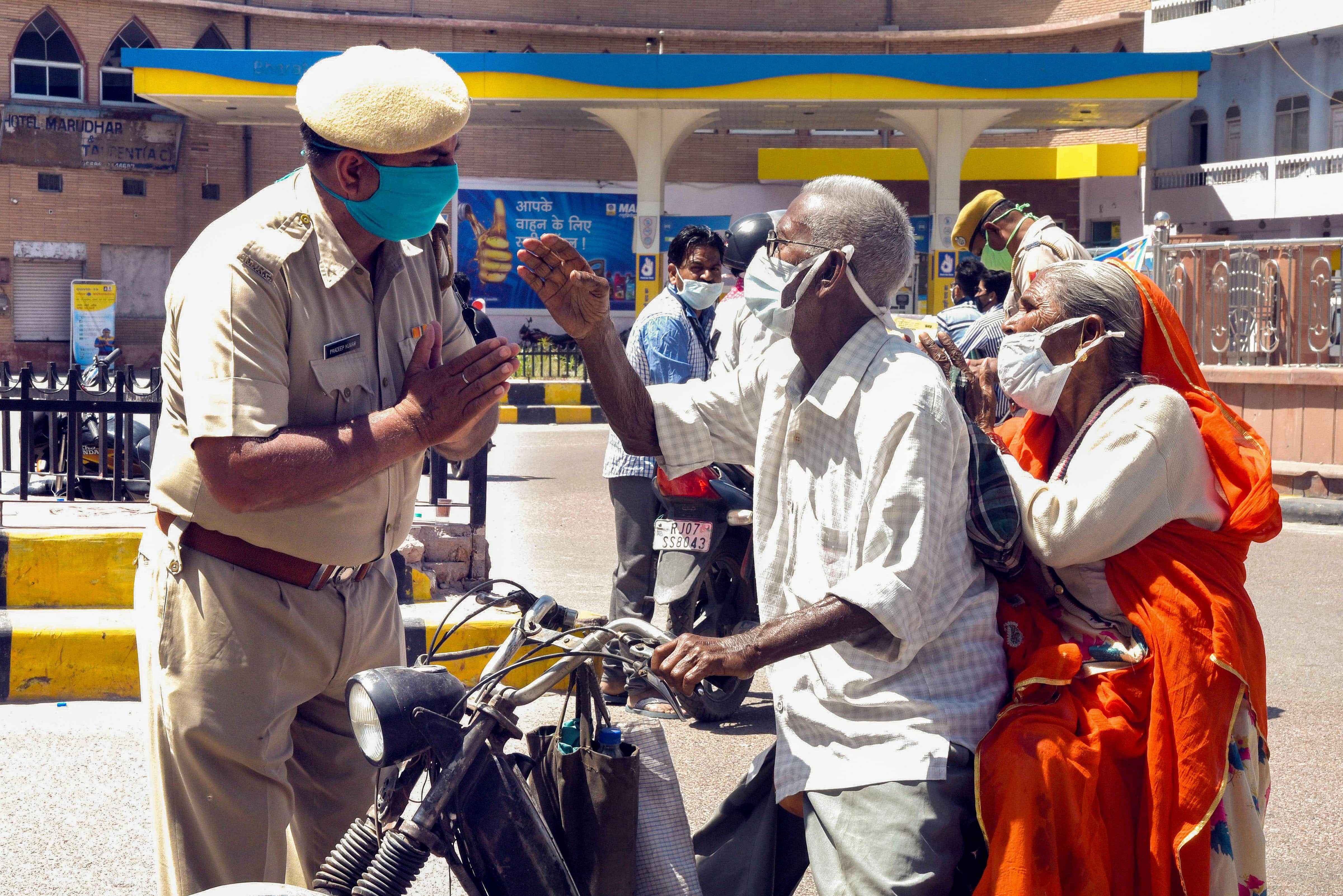 A policeman appeals commuters to stay home during the complete lockdown imposed in a bid to contain the spread of COVID-19, in Bikaner. (Credit: PTI Photo)