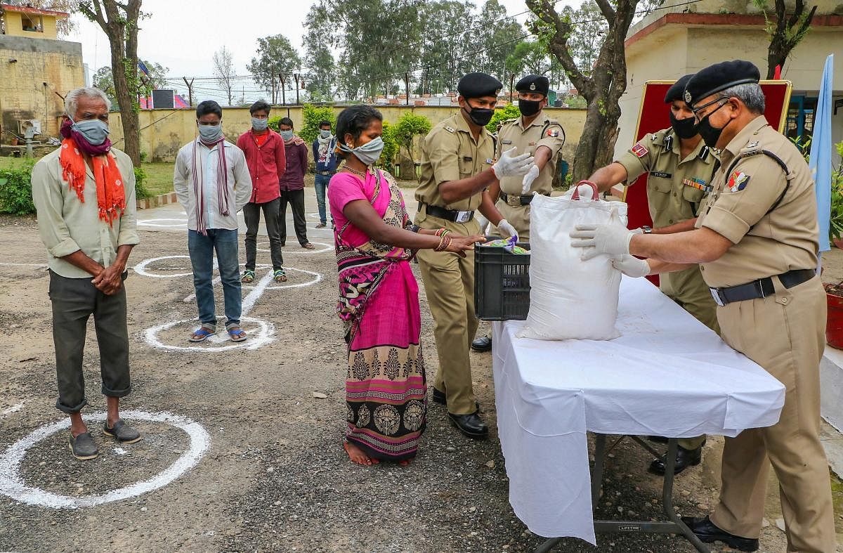 Border Security Force (BSF) personnel distribute food among needy people, maintaining safe distances, at Miramshib BSF Camp during the nationwide lockdown imposed in the wake of coronavirus pandemic, in Jammu, Monday, March 30, 2020. (PTI Photo) 