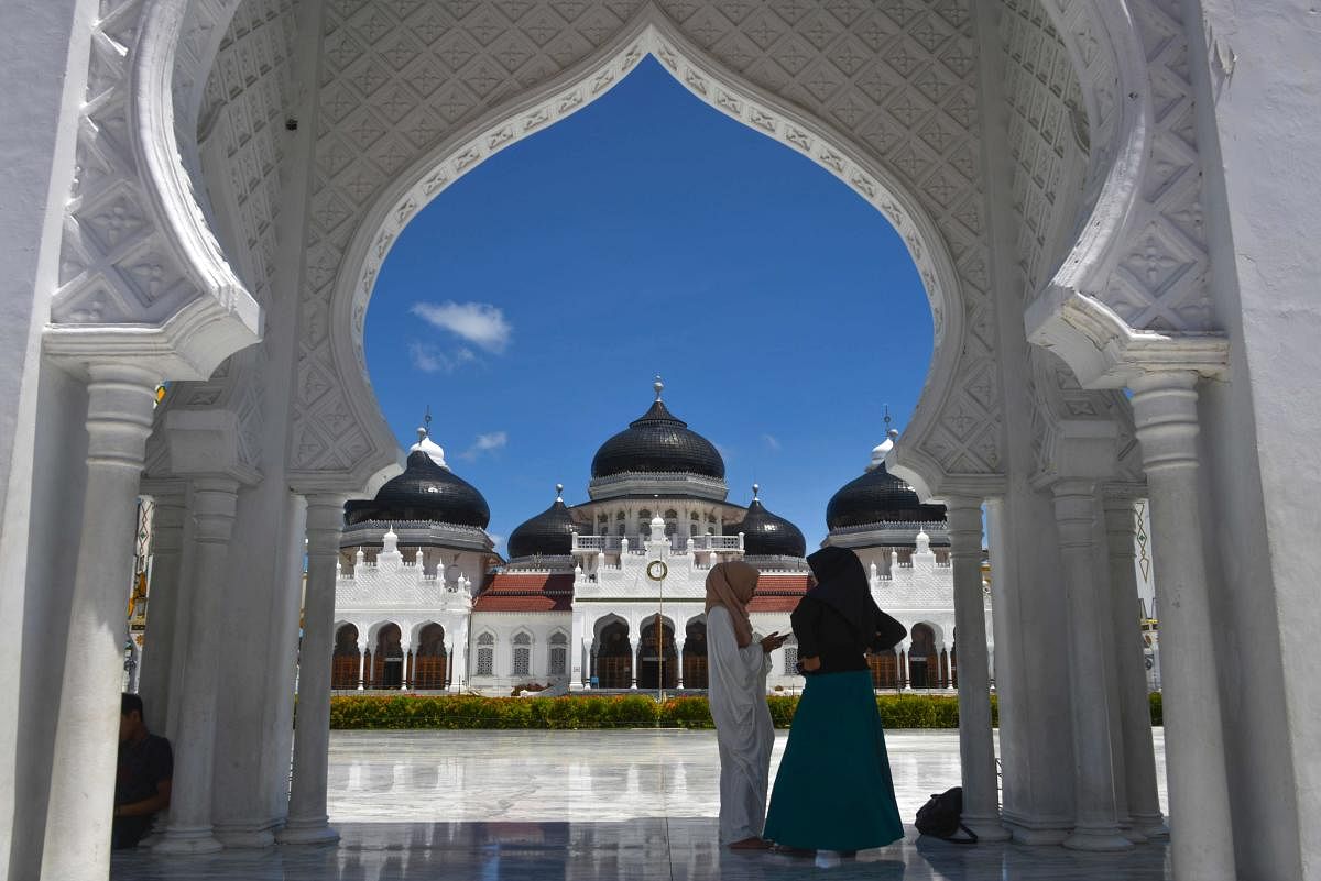 Muslim women stand outside Baiturrahman grand mosque during the Islamic holy month of Ramadan in Banda Aceh (AFP Photo)