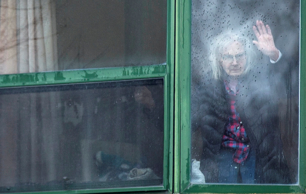 A resident waves from her window at Residence Herron, a senior's long-term care facility in Montreal. (Credit: Reuters)