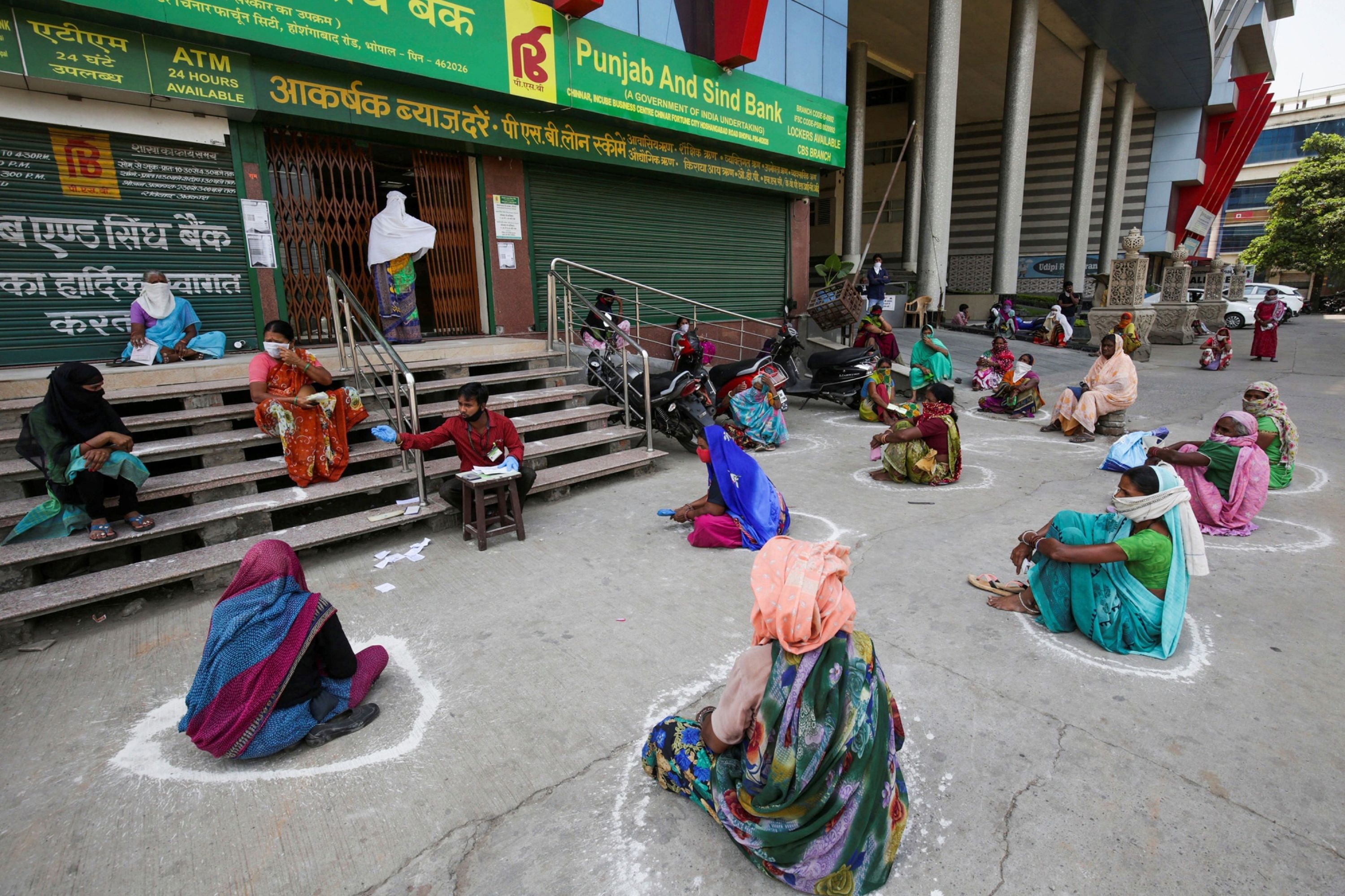 People following social-distancing guidelines wait in queues outside a government store to collect free ration under Pradhan Mantri Gareeb Kalyan Anna Yojna. (PTI Photo)