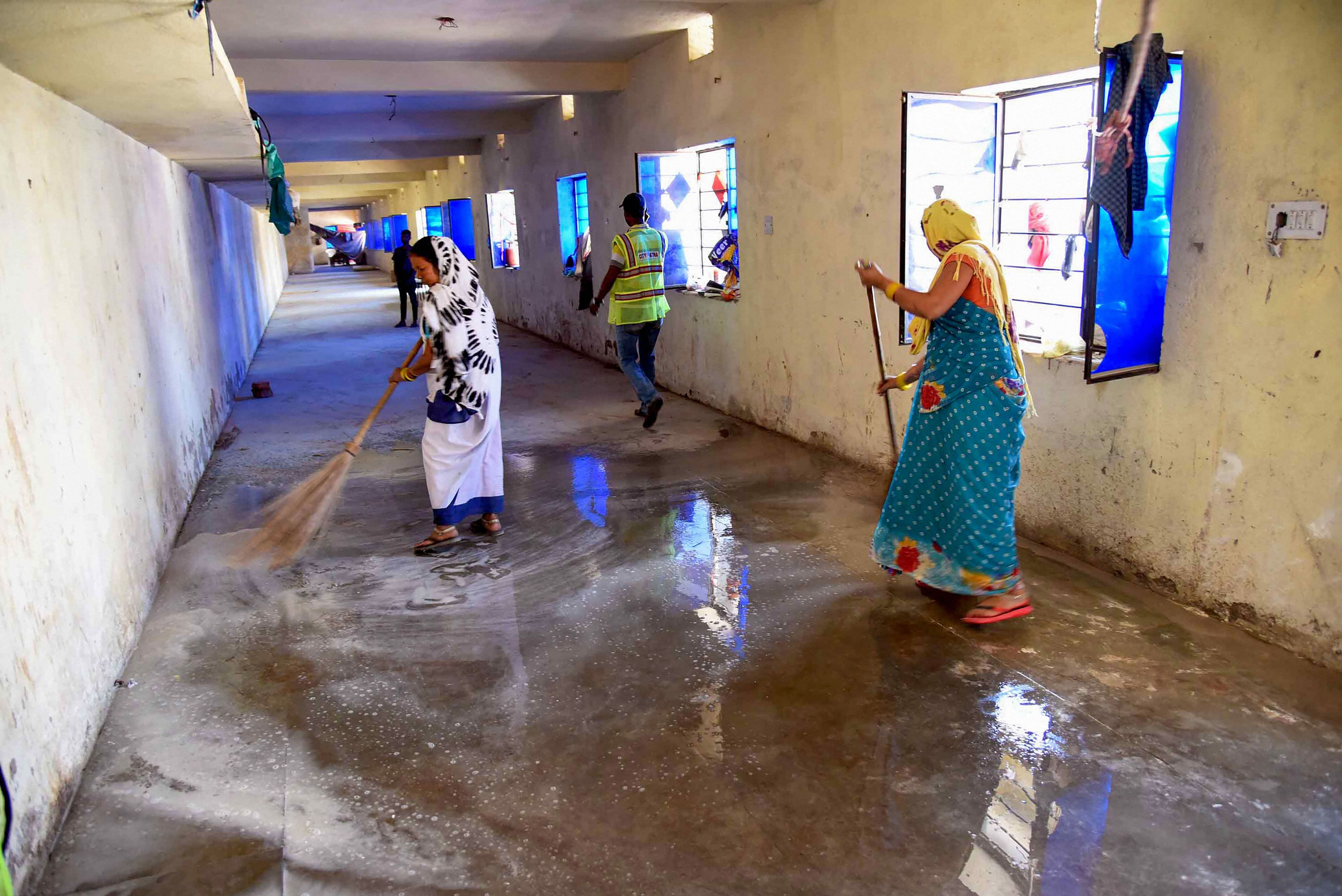 Patna: Municipal Corporation workers clean a Quarantine center during a nationwide lockdown in the wake of coronavirus outbreak. (Credit: PTI Photo)