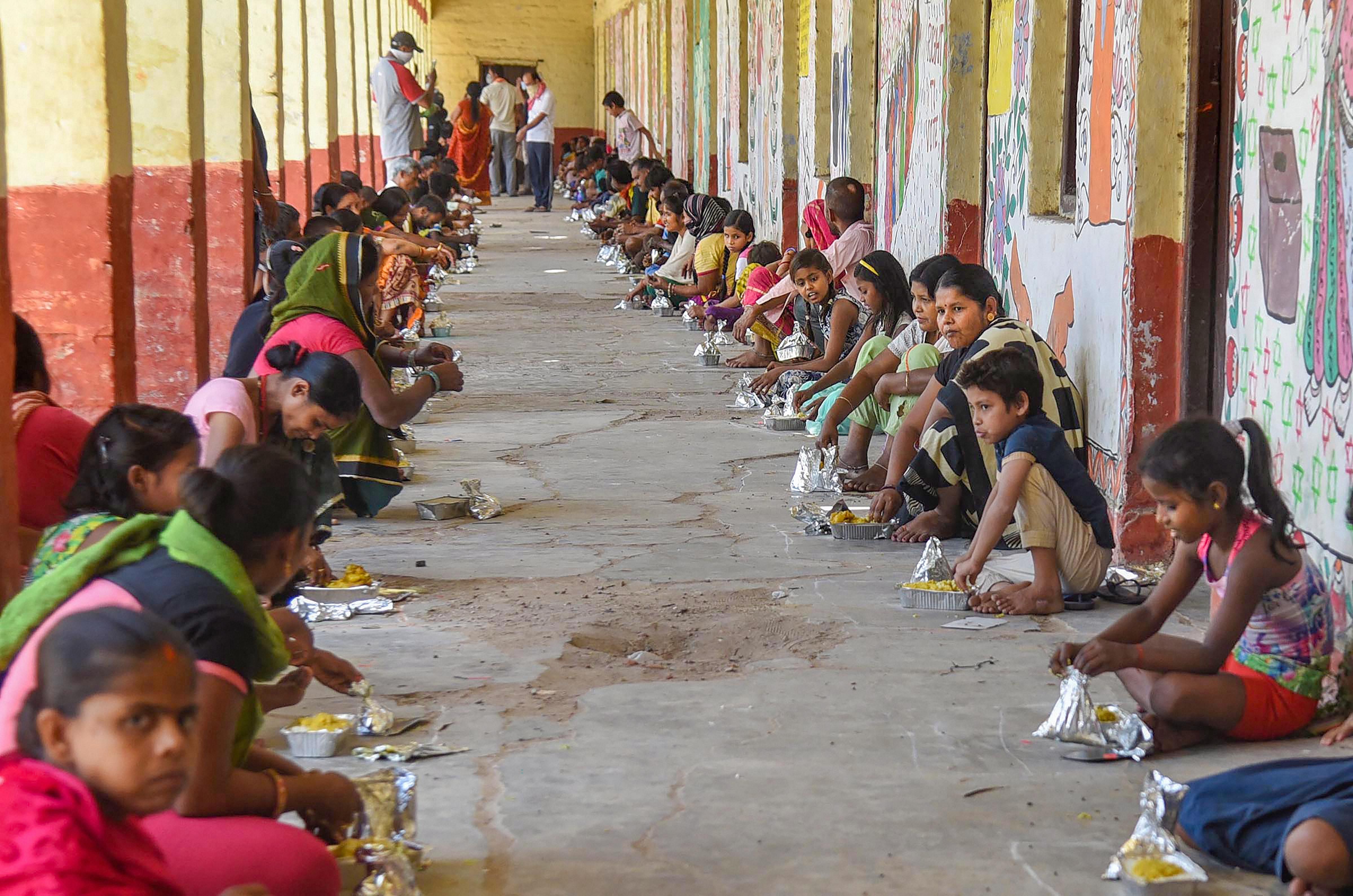 People have meal at a relief camp during the nationwide lockdown in the wake of the coronavirus pandemic, in Patna. (Credit: PTI)