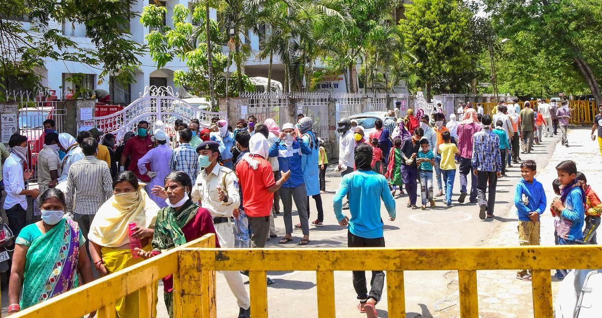 People gather at PCC headquarters to collect food packets amid a nationwide lockdown in the wake of coronavirus pandemic, in Bhopal, Saturday, April 4, 2020. (PTI Photo)