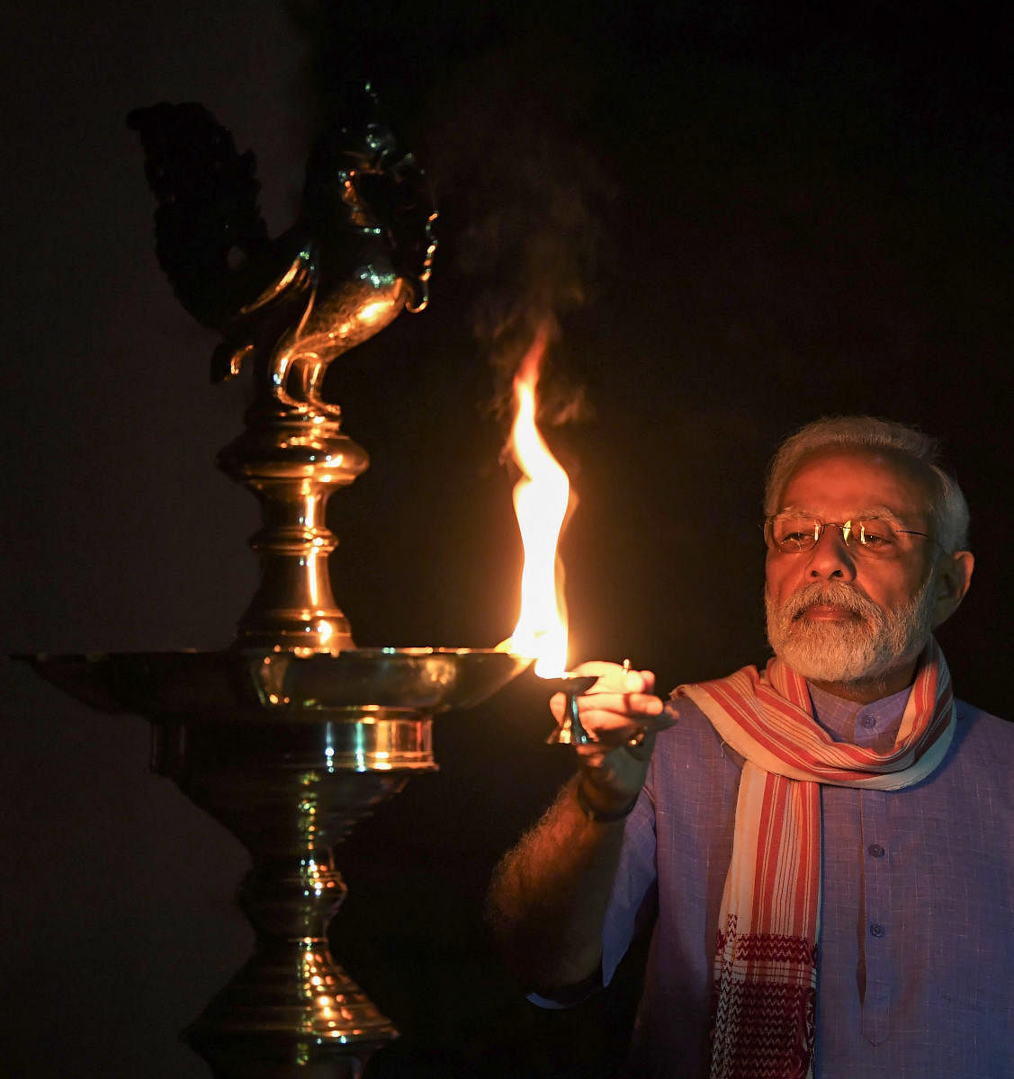 Prime Minister Narendra Modi lights a lamp during a nationwide lockdown in the wake of coronavirus pandemic. PTI