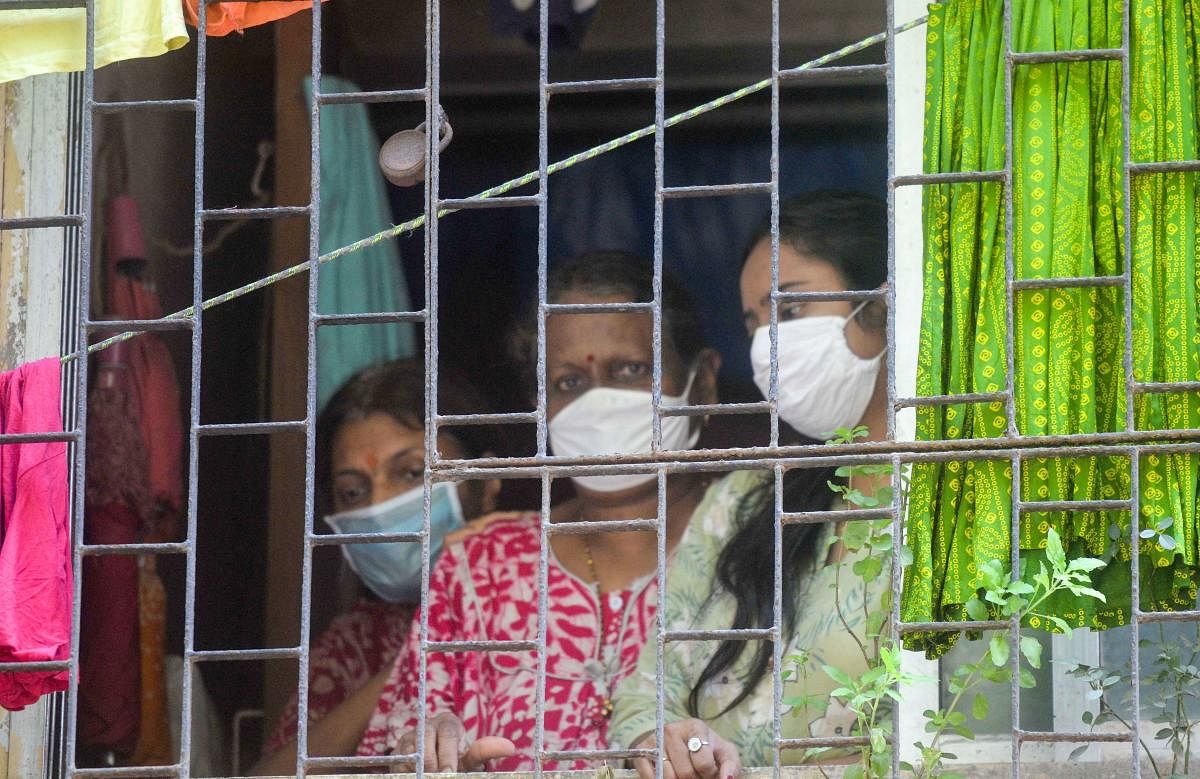  Women look through a window during a nationwide lockdown in the wake of coronavirus pandemic, at Dr. Baliga Nagar in Dharavi, Saturday, April 4, 2020. Credit: PTI Photo