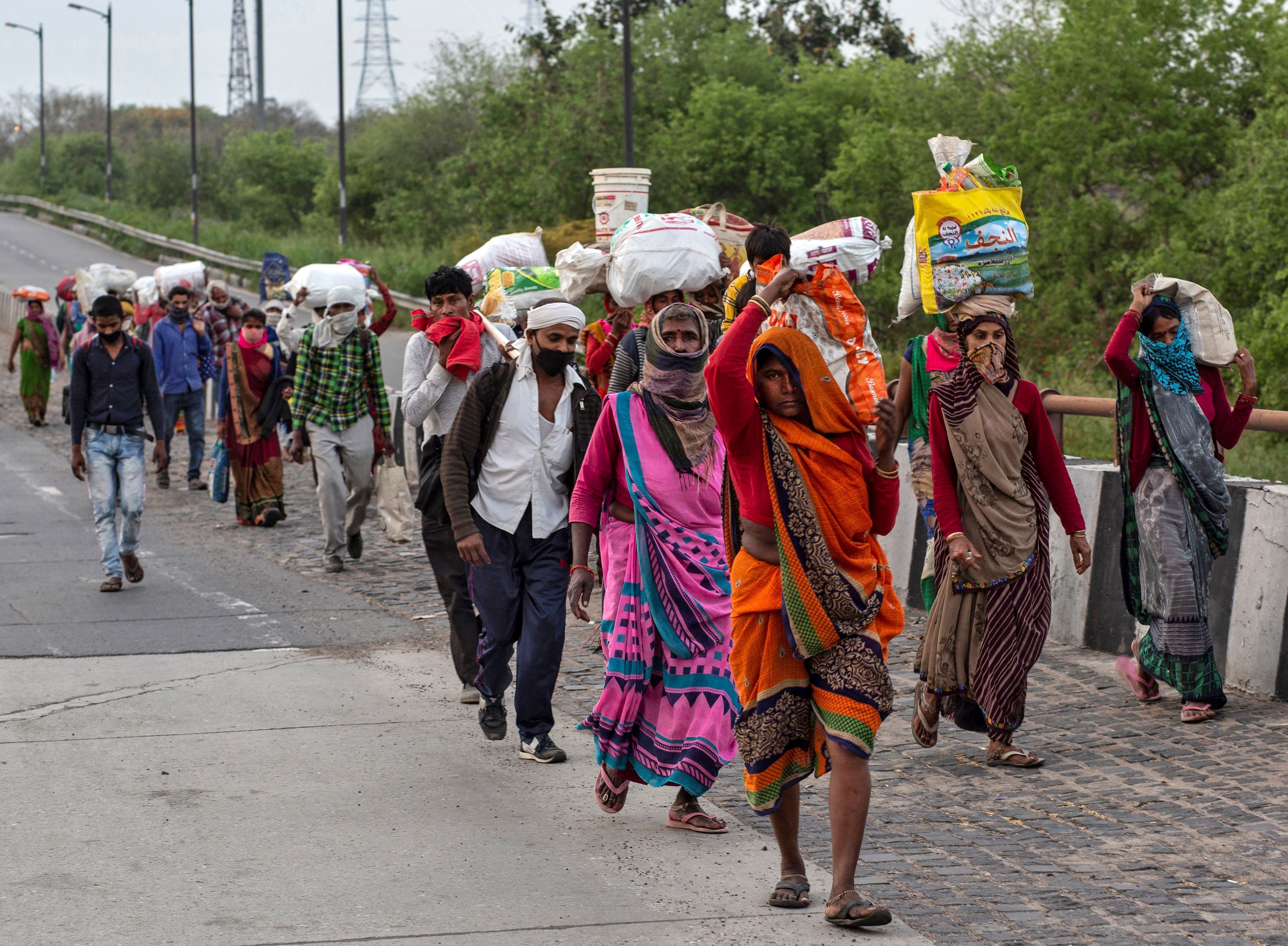 Friends and relatives of Kushwaha family who work as migrant workers walk along a road to return to their villages, during a 21-day nationwide lockdown to limit the spreading of coronavirus