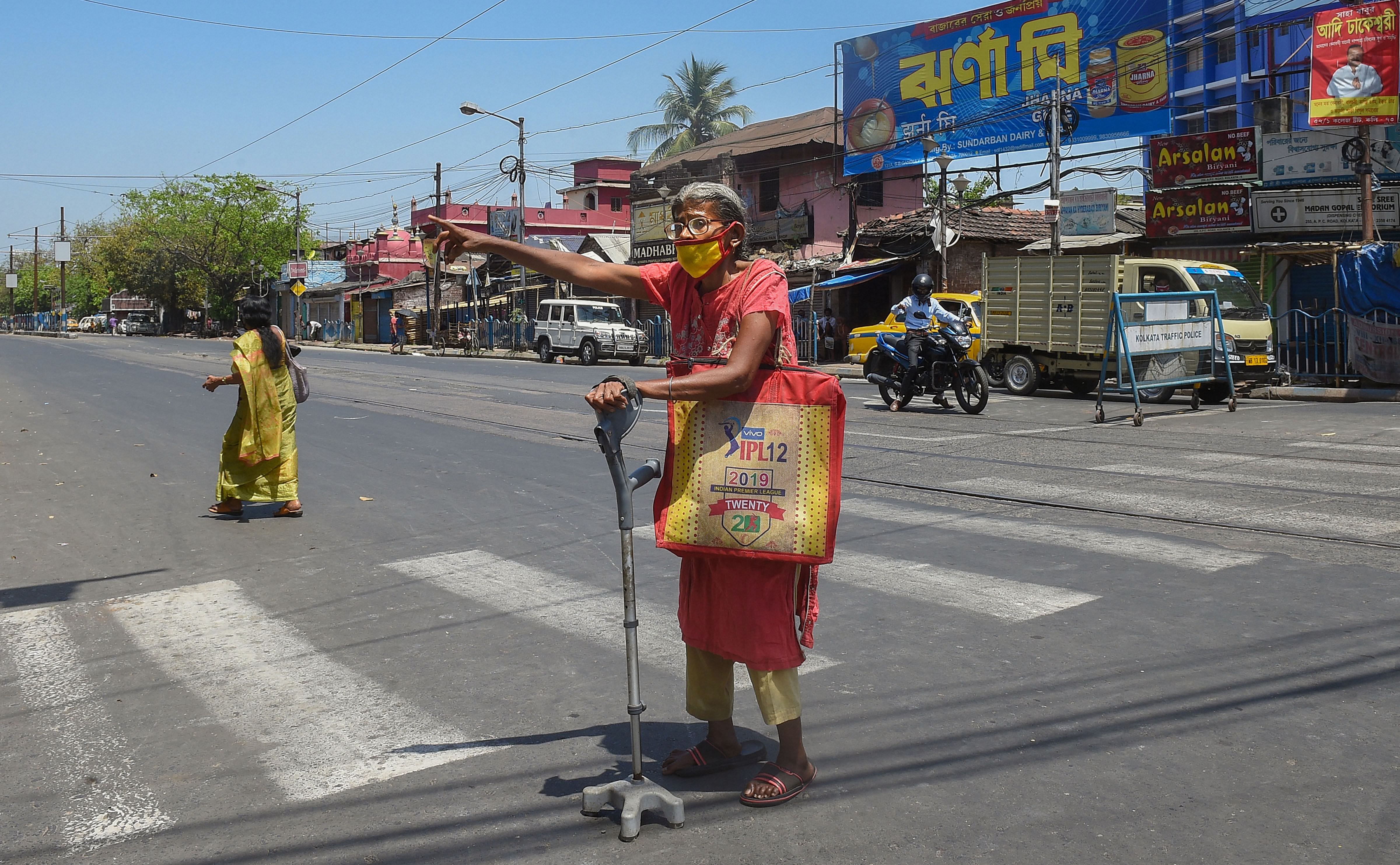 An elderly woman crosses a road during the nationwide lockdown imposed in the wake of coronavirus pandemic, in Kolkata. (PTI Photo)