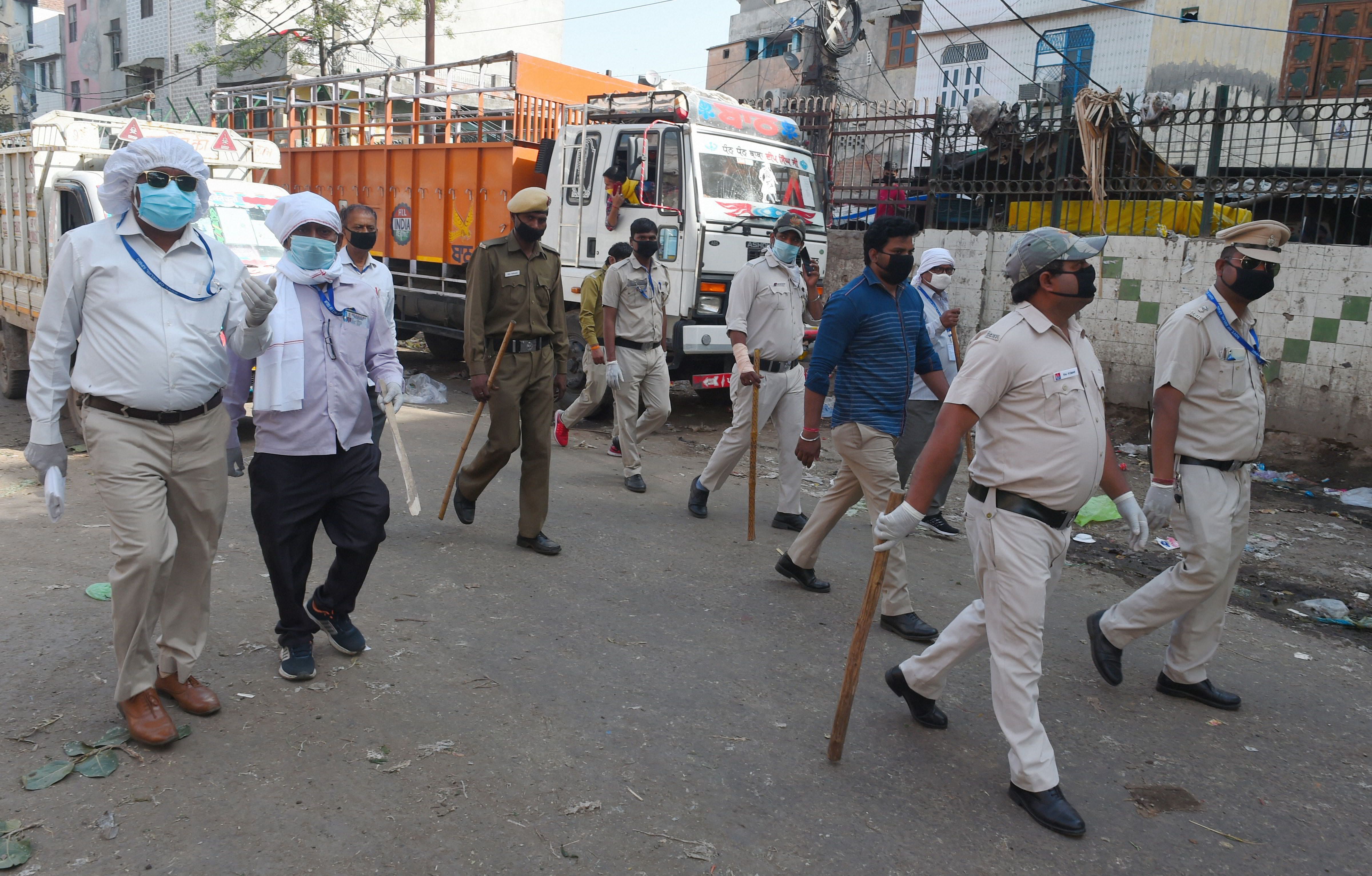 Government officials and Delhi Police personnel patrol Azadpur Mandi during the nationwide lockdown to curb the spread of coronavirus. (PTI Photo)