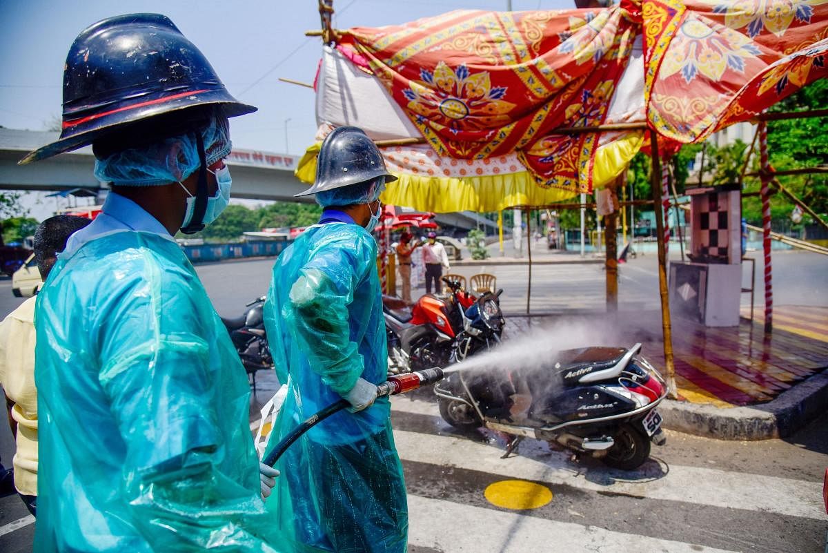 Firefighters spray disinfectant on a scooter as a preventive measure to curb the spread of coronavirus, during the nationwide lockdown, at Swargate chowk, in Pune, Friday, April 17, 2020. (PTI Photo)