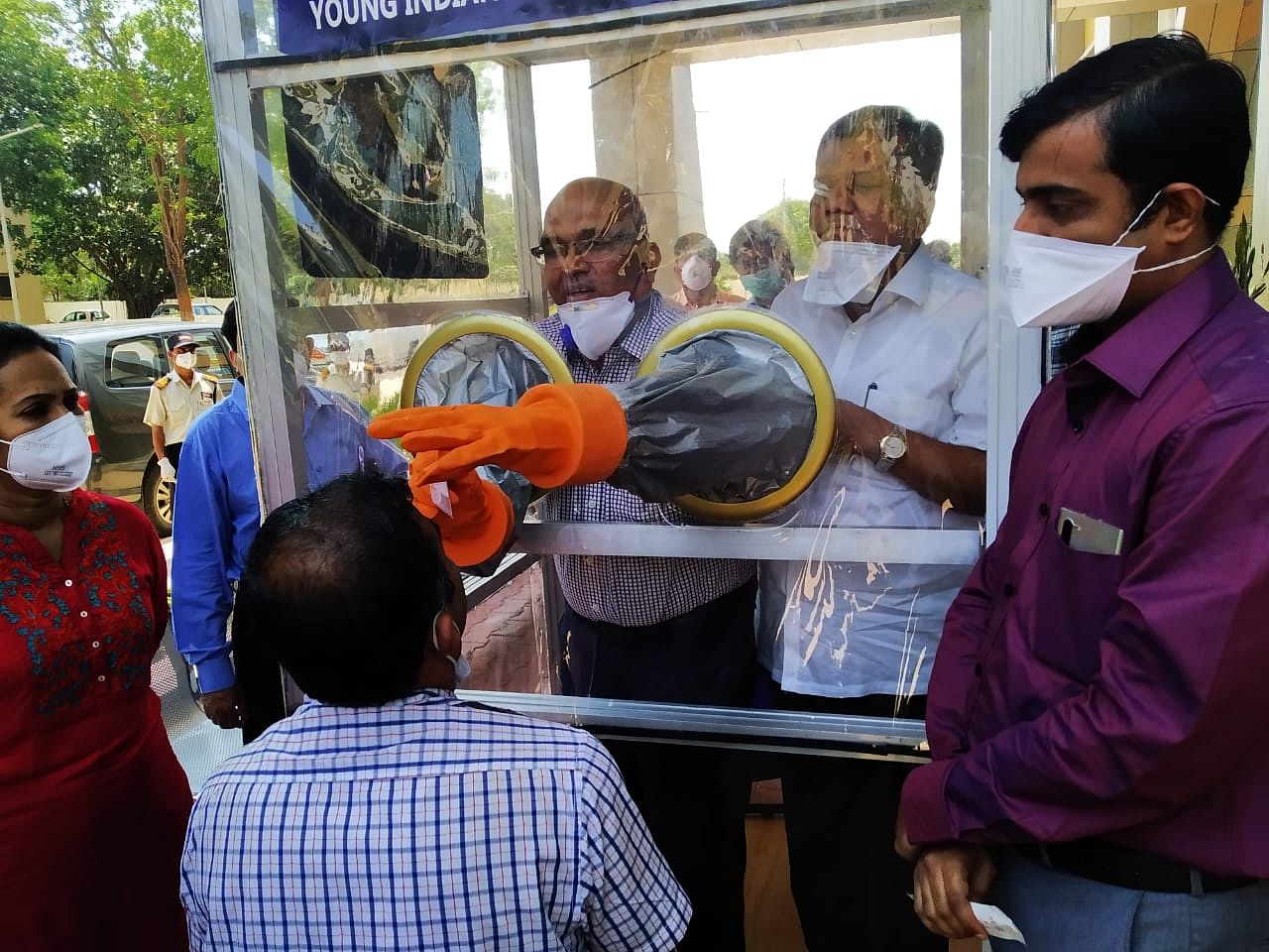 Industries Minister Jagadish Shettar observes throat swab collection demonstration using the swab collection box donated by Young Indians and Ladies Circle India, at KIMS in Hubballi on Wednesday. (Credi: DH Photo)