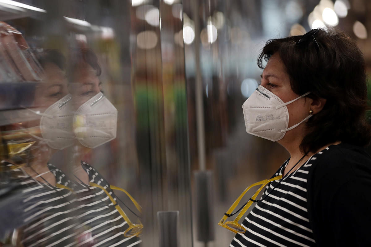 A woman wearing a face mask looks at food items at a supermarket following the outbreak of the coronavirus disease (COVID-19) in Madrid, Spain (Reuters Photo)