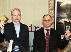 WikiLeaks founder Julian Assange, left, accompanied by former Swiss banker Rudolf Elmer, right, are seen after Elmer handed Assange two CD cases full of files, following a news conference at the Frontline Club in London, Monday. AP Photo