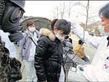 DEADLY EXPOSURE A hospital worker who was flown from a  shelter by helicopter receives a check for radiation contamination, in Nihonmatsu, Fukushima, northern Japan, on Sunday. AP