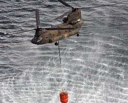 Japan's Self-Defense Forces's helicopter scoops water off Japan's northeast coast on its way to the Fukushima Dai-ichi nuclear power plant in Okumamachi Thursday morning, March 17, 2011. Helicopters are dumping water on a stricken reactor in northeastern Japan to cool overheated fuel rods inside the core.AP Photo
