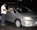 SPACE CONSTRAINT A motorist paying the parking fee at Kanteerava Stadium. DH photo