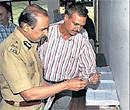 Commissioner of Police B G Jyothi Prakash Mirji and Joint Commissioner (Crime) Alok Kumar look at the siezed articles in Bangalore on Sunday. DH&#8200;Photo