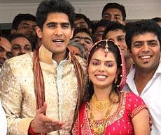 Boxer Vijender Singh with his wife Archana  poses for photographs after their marriage in New Delhi on Tuesday. PTI Photo