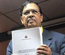 Karnataka Lokayukta Justice Santosh Hegde showing a copy of his report on illegal mining during a press conference in Bangalore on Wednesday. PTI