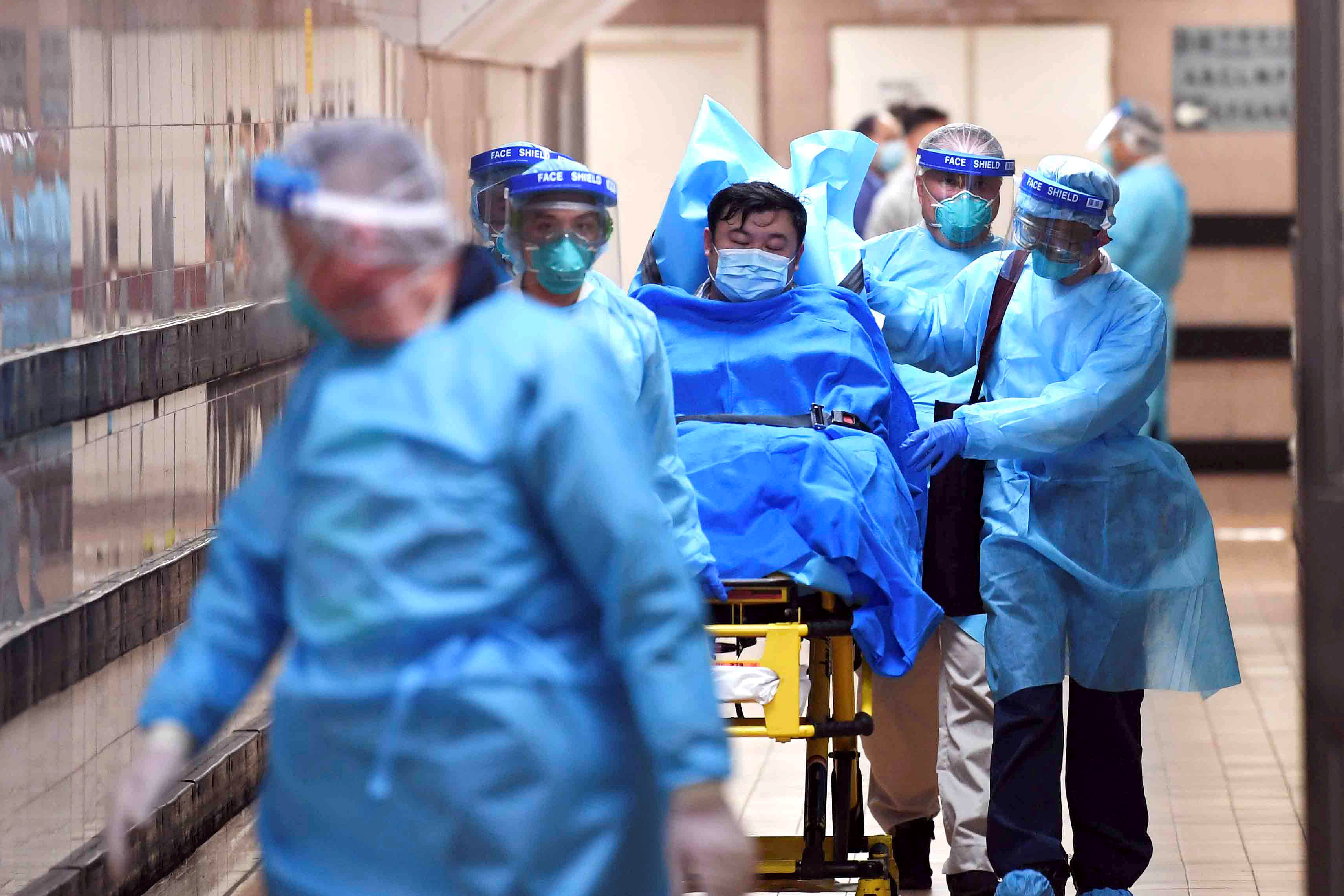 Medical staff transfer a patient of a highly suspected case of a new coronavirus at the Queen Elizabeth Hospital in Hong Kong. (Reuters Photo)