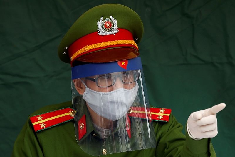 Police officer Nguyen Tien Thanh wears a protective face shield as he takes the duty at a health check point on a road during coronavirus disease (COVID-19) outbreak in Hanoi, Vietnam. (Reuters Photo)