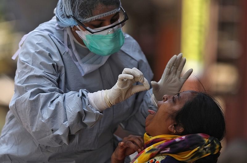 A doctor wearing a protective gear takes a swab from a woman to test for coronavirus disease (COVID-19), in Dharavi. (Reuters Photo)