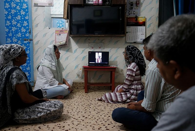 A family attends a live broadcast of a mass inside their house on Good Friday during a 21-day nationwide lockdown to slow the spreading of coronavirus disease. (Reuters Photo)
