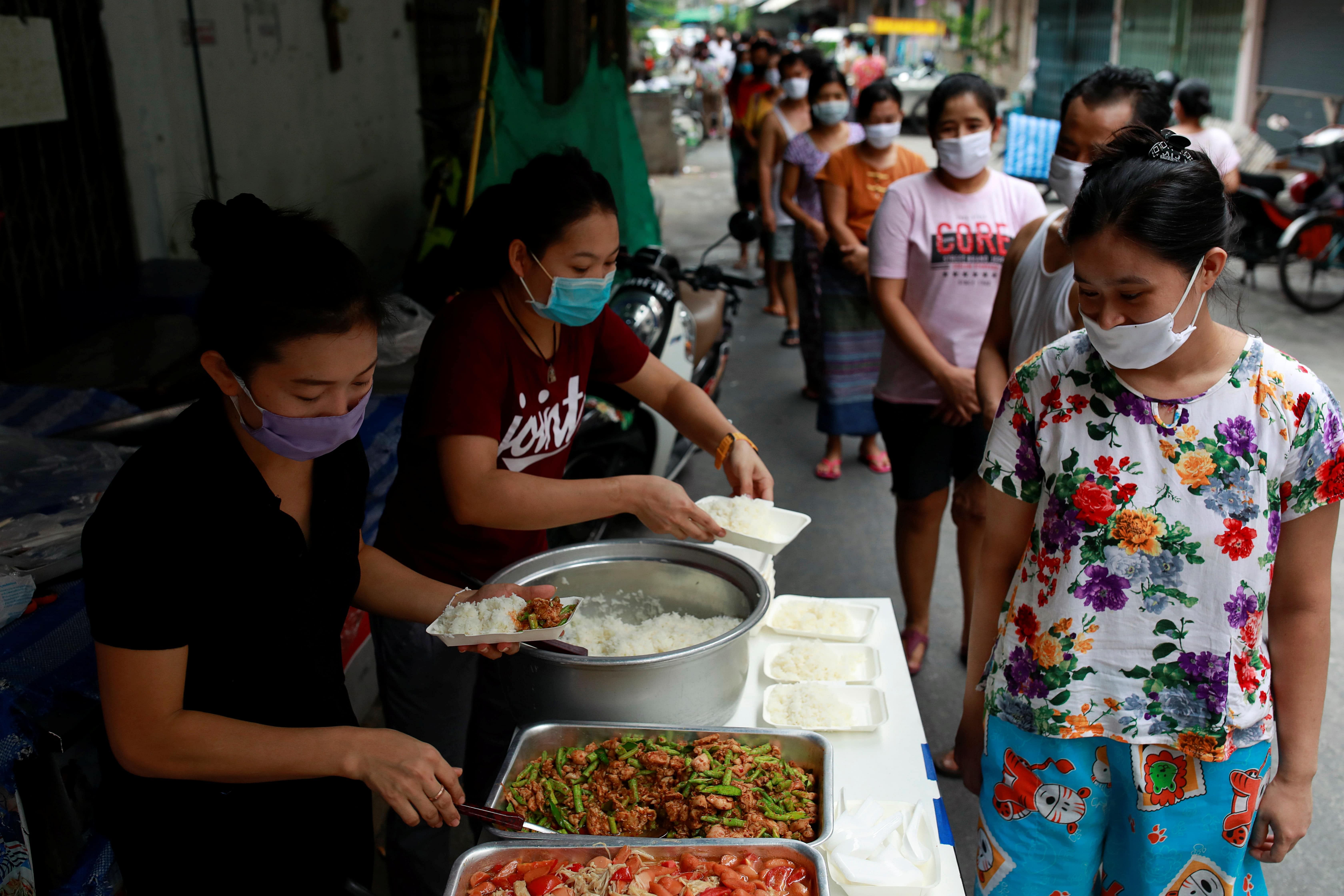 Volunteers give free foods for migrant workers from Myanmar who lost their jobs following the coronavirus disease. (Credit: Reuters Photo)