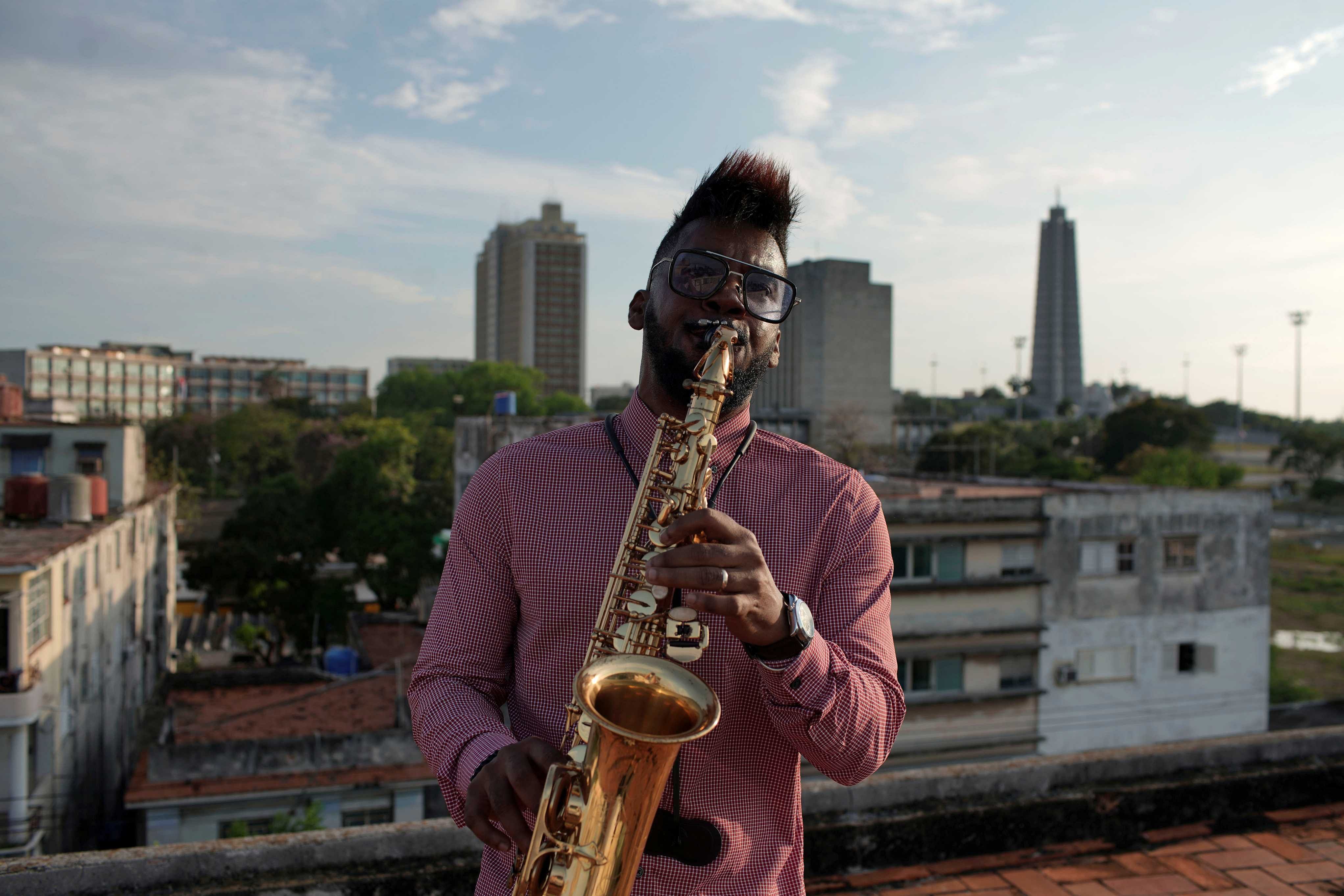 Saxophonist Michel Herrera performs for a TV camera on a rooftop in Havana, Cuba (Reuters)