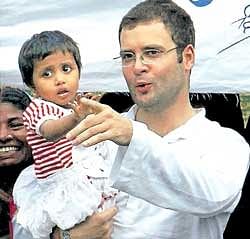 AICC General Secretary Rahul Gandhi holds a child at Khalispur village during his three-day visit to Amethi on Monday. PTI